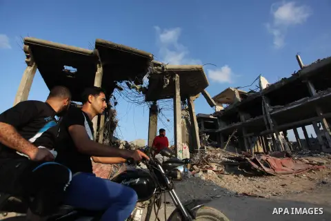 Palestinians walks past buildings destroyed during fighting between Hamas militants and Israel in the Al-Shaaf neighbourhood, in Gaza City, on August 18, 2014.Prime Minister Benjamin Netanyahu warned that Israel will hit...