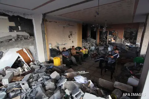Palestinians walks past buildings destroyed during fighting between Hamas militants and Israel in the Al-Shaaf neighbourhood, in Gaza City, on August 18, 2014.Prime Minister Benjamin Netanyahu warned that Israel will hit...