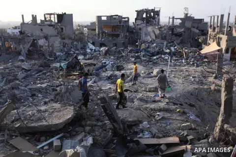 Palestinians walks past buildings destroyed during fighting between Hamas militants and Israel in the Al-Shaaf neighbourhood, in Gaza City, on August 18, 2014.Prime Minister Benjamin Netanyahu warned that Israel will hit...