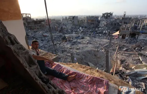 Palestinians walks past buildings destroyed during fighting between Hamas militants and Israel in the Al-Shaaf neighbourhood, in Gaza City, on August 18, 2014.Prime Minister Benjamin Netanyahu warned that Israel will hit...