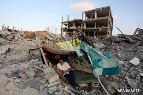 Palestinians walks past buildings destroyed during fighting between Hamas militants and Israel in the Al-Shaaf neighbourhood, in Gaza City, on August 18, 2014.Prime Minister Benjamin Netanyahu warned that Israel will hit...