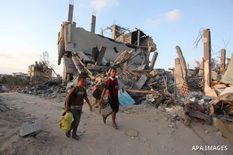 Palestinians walks past buildings destroyed during fighting between Hamas militants and Israel in the Al-Shaaf neighbourhood, in Gaza City, on August 18, 2014.Prime Minister Benjamin Netanyahu warned that Israel will hit...
