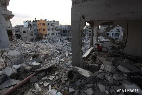 Palestinians walks past buildings destroyed during fighting between Hamas militants and Israel in the Al-Shaaf neighbourhood, in Gaza City, on August 18, 2014.Prime Minister Benjamin Netanyahu warned that Israel will hit...