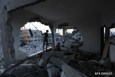Palestinians walks past buildings destroyed during fighting between Hamas militants and Israel in the Al-Shaaf neighbourhood, in Gaza City, on August 18, 2014.Prime Minister Benjamin Netanyahu warned that Israel will hit...