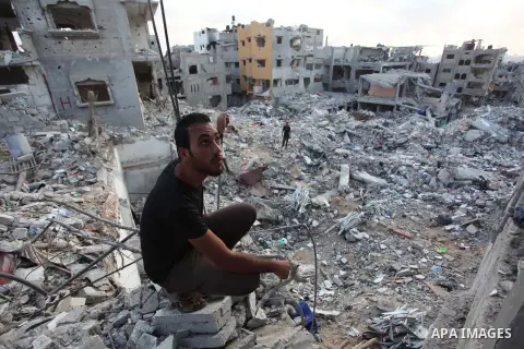 Palestinians walks past buildings destroyed during fighting between Hamas militants and Israel in the Al-Shaaf neighbourhood, in Gaza City, on August 18, 2014.Prime Minister Benjamin Netanyahu warned that Israel will hit...