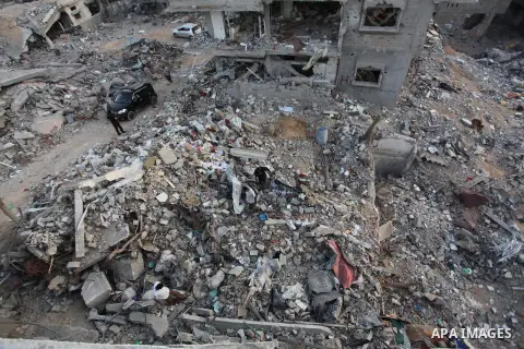 Palestinians walks past buildings destroyed during fighting between Hamas militants and Israel in the Al-Shaaf neighbourhood, in Gaza City, on August 18, 2014.Prime Minister Benjamin Netanyahu warned that Israel will hit...