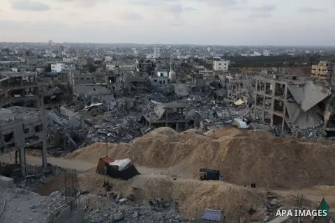 Palestinians walks past buildings destroyed during fighting between Hamas militants and Israel in the Al-Shaaf neighbourhood, in Gaza City, on August 18, 2014.Prime Minister Benjamin Netanyahu warned that Israel will hit...