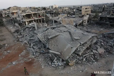 Palestinians walks past buildings destroyed during fighting between Hamas militants and Israel in the Al-Shaaf neighbourhood, in Gaza City, on August 18, 2014.Prime Minister Benjamin Netanyahu warned that Israel will hit...