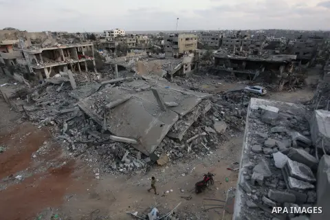 Palestinians walks past buildings destroyed during fighting between Hamas militants and Israel in the Al-Shaaf neighbourhood, in Gaza City, on August 18, 2014.Prime Minister Benjamin Netanyahu warned that Israel will hit...