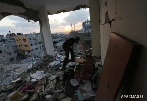 Palestinians walks past buildings destroyed during fighting between Hamas militants and Israel in the Al-Shaaf neighbourhood, in Gaza City, on August 18, 2014.Prime Minister Benjamin Netanyahu warned that Israel will hit...
