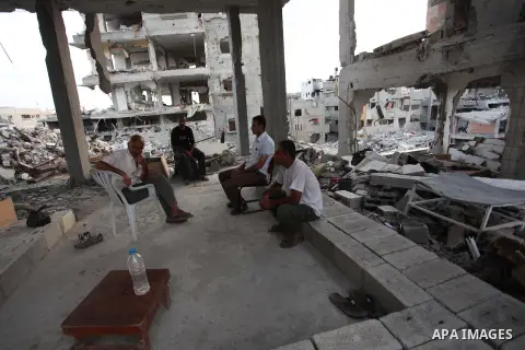 Palestinians walks past buildings destroyed during fighting between Hamas militants and Israel in the Al-Shaaf neighbourhood, in Gaza City, on August 18, 2014.Prime Minister Benjamin Netanyahu warned that Israel will hit...