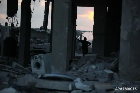 Palestinians walks past buildings destroyed during fighting between Hamas militants and Israel in the Al-Shaaf neighbourhood, in Gaza City, on August 18, 2014.Prime Minister Benjamin Netanyahu warned that Israel will hit...