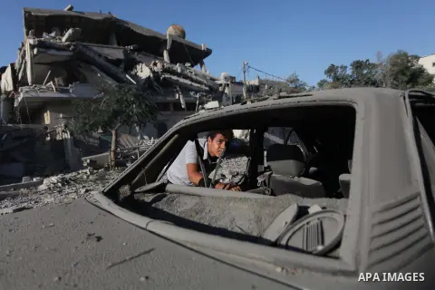 A Palestinian man looks inside a damaged car parked outside destroyed homes following an Israeli airstrikes on the Jabalia Palestinian refugee camp in the Gaza Strip, on August 20, 2014. Hamas said that an Israeli air st...