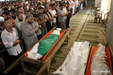Palestinians pray on the bodies of the wife of Hamas's military leader, Mohammed Deif, and his infant son Ali, whom medics said were killed in Israeli air strikes, in the northern Gaza Strip August 20, 2014. Israeli air...