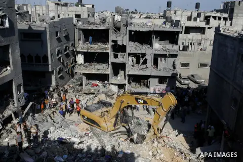 Palestinian rescue workers use an excavator to remove the dead body of a man from under the rubble of a house, which witnesses said was destroyed in an Israeli air strike, in Rafah in the southern Gaza Strip August 21, 2...