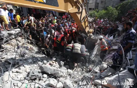 Palestinian rescue workers use an excavator to remove the dead body of a man from under the rubble of a house, which witnesses said was destroyed in an Israeli air strike, in Rafah in the southern Gaza Strip August 21, 2...