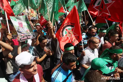 Palestinian protesters wave flags of the Islamist movement Hamas during a demonstration to show support to its militants in the Gaza Strip on August 22, 2014 in the West Bank city of Ramallah. Hostilities in the six-week...