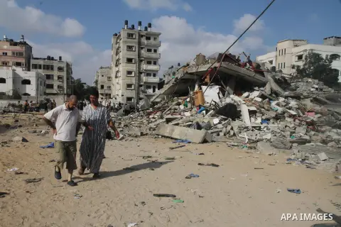 Palestinians gather around the remains of a house, which witnesses said was destroyed in an Israeli air strike, in Gaza City August 23, 2014. Hamas-led gunmen in Gaza executed 18 Palestinians accused of collaborating wit...