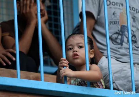 A Palestinian girl watches children participating in recreational events at a UN school, that shelters hundreds of families after fighting between Israel and Hamas broke out July 8, during a morning activity on the day t...