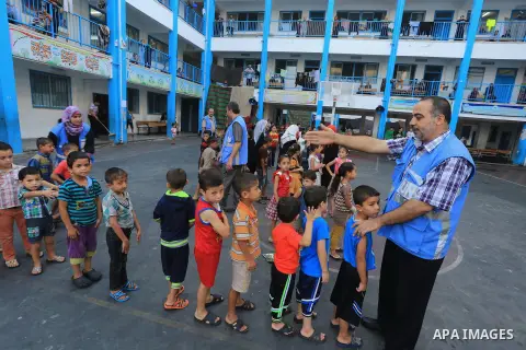 Palestinian children enjoy in games in the courtyard of a UN school, that shelters hundreds of families after fighting between Israel and Hamas broke out July 8, during a morning activity on the day that schools across G...