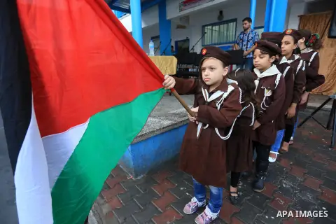 Palestinian children line up in the courtyard of a UN school, that shelters hundreds of families after fighting between Israel and Hamas broke out July 8, during a morning activity on the day that schools across Gaza wer...