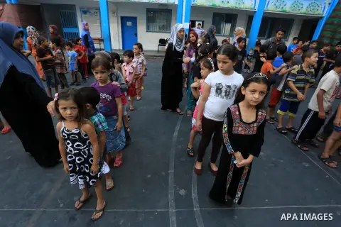 Palestinian children enjoy in games in the courtyard of a UN school, that shelters hundreds of families after fighting between Israel and Hamas broke out July 8, during a morning activity on the day that schools across G...