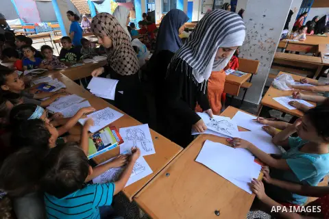 Palestinian children enjoy in games in the courtyard of a UN school, that shelters hundreds of families after fighting between Israel and Hamas broke out July 8, during a morning activity on the day that schools across G...