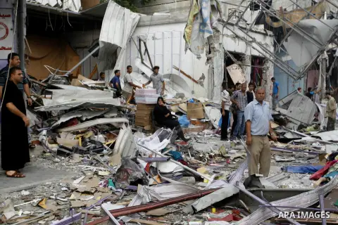 Palestinians look at the remains of a commercial center, which witnesses said was hit by an Israeli air strike on Saturday, in Rafah in the southern Gaza Strip August 24, 2014. Egypt called on Israel and the Palestinians...
