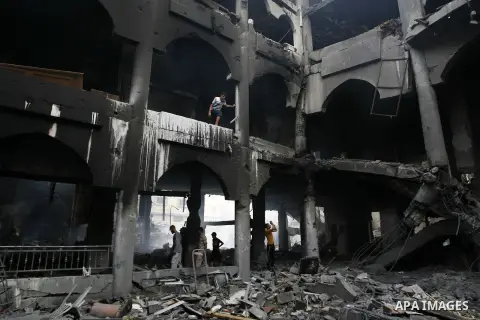 Palestinians look at the remains of a commercial center, which witnesses said was hit by an Israeli air strike on Saturday, in Rafah in the southern Gaza Strip August 24, 2014. Egypt called on Israel and the Palestinians...
