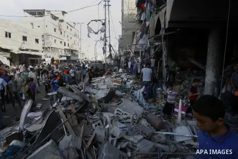 Palestinians look at the remains of a commercial center, which witnesses said was hit by an Israeli air strike on Saturday, in Rafah in the southern Gaza Strip August 24, 2014. Egypt called on Israel and the Palestinians...