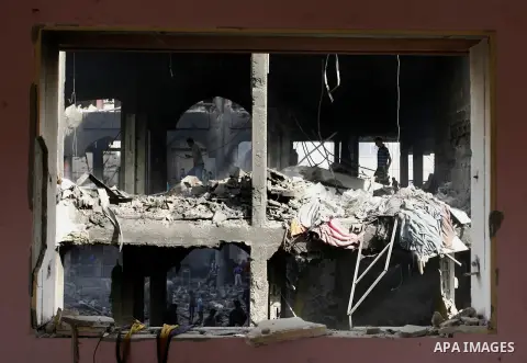 Palestinians look at the remains of a commercial center, which witnesses said was hit by an Israeli air strike on Saturday, in Rafah in the southern Gaza Strip August 24, 2014. Egypt called on Israel and the Palestinians...