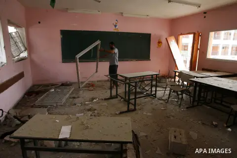 A Palestinian man inspects a classroom, which witnesses said was damaged by an Israeli air strike, at a school in Rafah in the southern Gaza Strip August 24, 2014. The Palestinian Ministry of Education said that while 70...