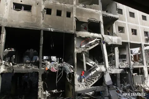 Palestinians look at the remains of a commercial center, which witnesses said was hit by an Israeli air strike on Saturday, in Rafah in the southern Gaza Strip August 24, 2014. Egypt called on Israel and the Palestinians...