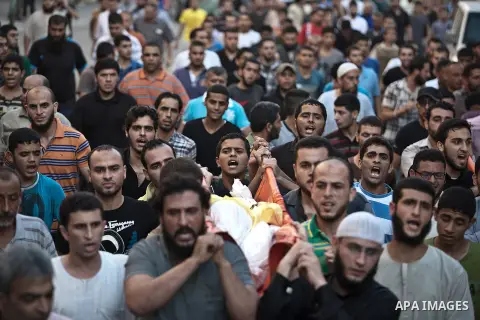 Mourners carry the body of one of four Palestinians from the Juda family, whom medics said were killed in an Israeli air strike, during their funeral in Jabaliya in the northern Gaza Strip August 24, 2014. Israeli Prime...