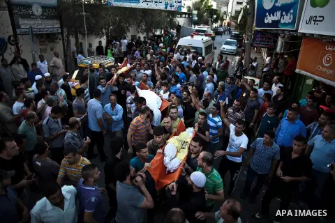 Mourners carry the body of one of four Palestinians from the Juda family, whom medics said were killed in an Israeli air strike, during their funeral in Jabaliya in the northern Gaza Strip August 24, 2014. Israeli Prime...