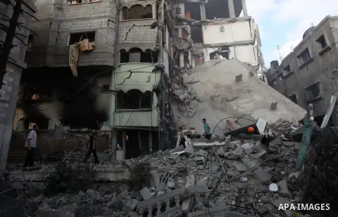 Palestinians inspect Al-Rahma Charity Association targeted in an Israeli air strike in Khan Younis in the southern Gaza strip on August 25, 2014. An Israeli air raid in Gaza left two Palestinians dead overnight, taking t...