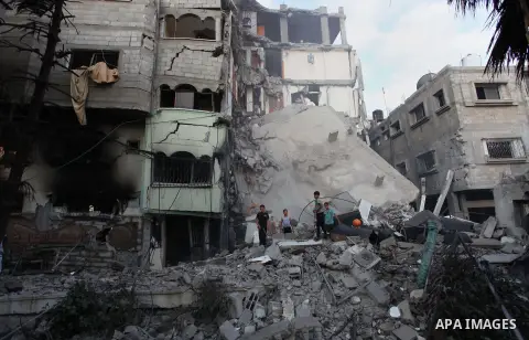 Palestinians inspect Al-Rahma Charity Association targeted in an Israeli air strike in Khan Younis in the southern Gaza strip on August 25, 2014. An Israeli air raid in Gaza left two Palestinians dead overnight, taking t...