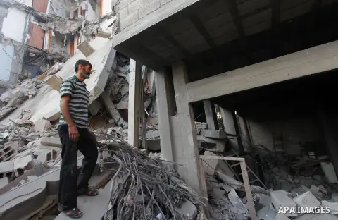 Palestinians inspect Al-Rahma Charity Association targeted in an Israeli air strike in Khan Younis in the southern Gaza strip on August 25, 2014. An Israeli air raid in Gaza left two Palestinians dead overnight, taking t...