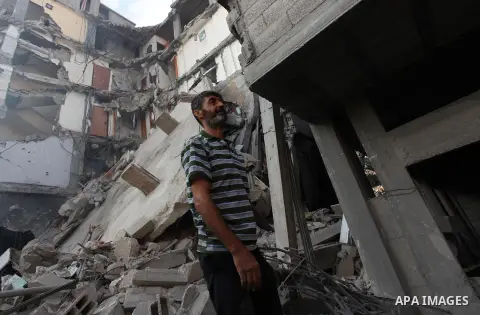 Palestinians inspect Al-Rahma Charity Association targeted in an Israeli air strike in Khan Younis in the southern Gaza strip on August 25, 2014. An Israeli air raid in Gaza left two Palestinians dead overnight, taking t...