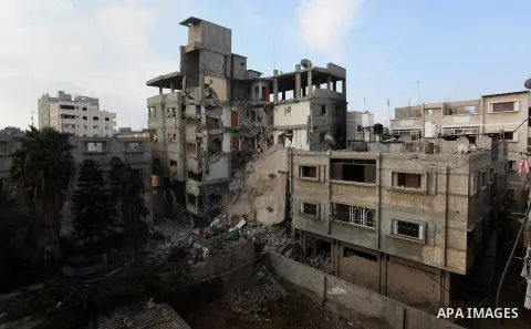 Palestinians inspect Al-Rahma Charity Association targeted in an Israeli air strike in Khan Younis in the southern Gaza strip on August 25, 2014. An Israeli air raid in Gaza left two Palestinians dead overnight, taking t...