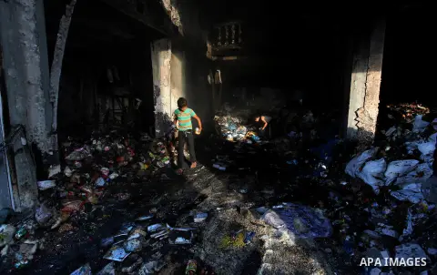 Palestinians inspect Al-Rahma Charity Association targeted in an Israeli air strike in Khan Younis in the southern Gaza strip on August 25, 2014. An Israeli air raid in Gaza left two Palestinians dead overnight, taking t...