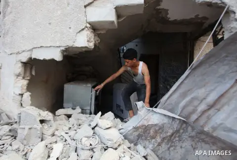 A Palestinian boy inspects a building of al-Ghul's house after it was targeted in an Israeli airstrike in Gaza City on August 25, 2014. One of Sunday's air strikes killed Hamas financial official Mohammed al-Ghul as he w...