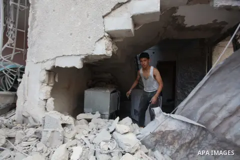 A Palestinian boy inspects a building of al-Ghul's house after it was targeted in an Israeli airstrike in Gaza City on August 25, 2014. One of Sunday's air strikes killed Hamas financial official Mohammed al-Ghul as he w...