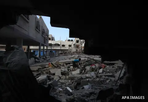 A Palestinian boy inspects a building of al-Ghul's house after it was targeted in an Israeli airstrike in Gaza City on August 25, 2014. One of Sunday's air strikes killed Hamas financial official Mohammed al-Ghul as he w...