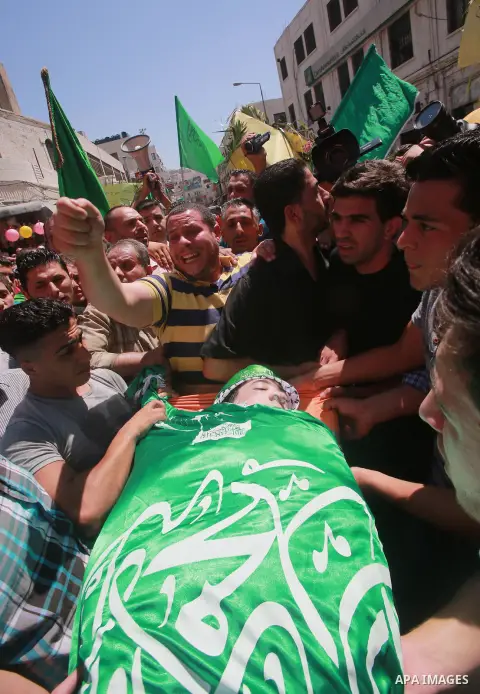 Palestinians carry the body of Hassan Ashour, a Palestinian teenager who died of his injuries, during his funeral on August 25, 2014 in the West Bank city of Nablus. Hassan Ashur was shot in the abdomen with live fire as...