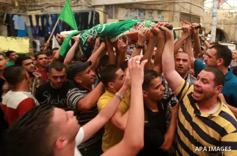 Palestinians carry the body of Hassan Ashour, a Palestinian teenager who died of his injuries, during his funeral on August 25, 2014 in the West Bank city of Nablus. Hassan Ashur was shot in the abdomen with live fire as...