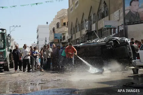 A Palestinian cleans a street with a hose after what witnesses said was an Israeli air strike on a car, in Gaza City August 25, 2014. Israeli air strikes killed at least five Palestinians in the Gaza Strip and militants...