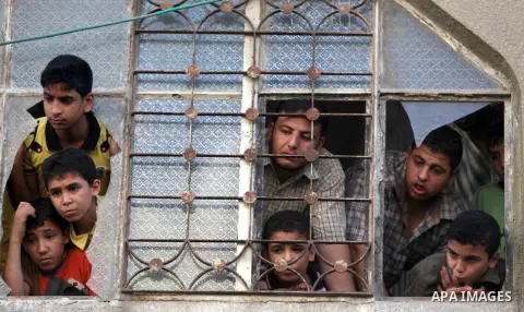 Palestinians mourn over the bodies of Basim Hijazi 36, his brother Ahmed, 26, and a friend Mohamad al-Dali who were killed when their car was hit by an Israeli air strike during their funeral in Gaza City on August 25, 2...