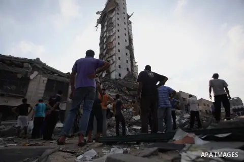 Palestinians gather around the remains of one of Gaza's tallest apartment towers, which witnesses said was hit by an Israeli air strike that destroyed much of it, in Gaza City August 26, 2014. Israeli air strikes launche...