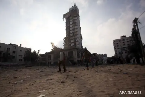 Palestinians gather around the remains of one of Gaza's tallest apartment towers, which witnesses said was hit by an Israeli air strike that destroyed much of it, in Gaza City August 26, 2014. Israeli air strikes launche...